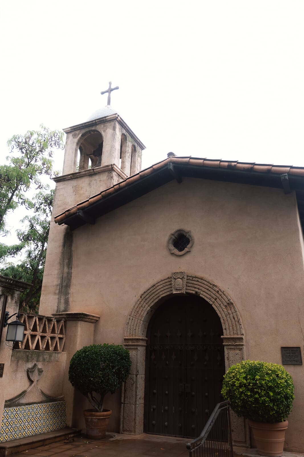 Exterior view of a Spanish-style chapel with an arched doorway and bell tower at Tlaquepaque.