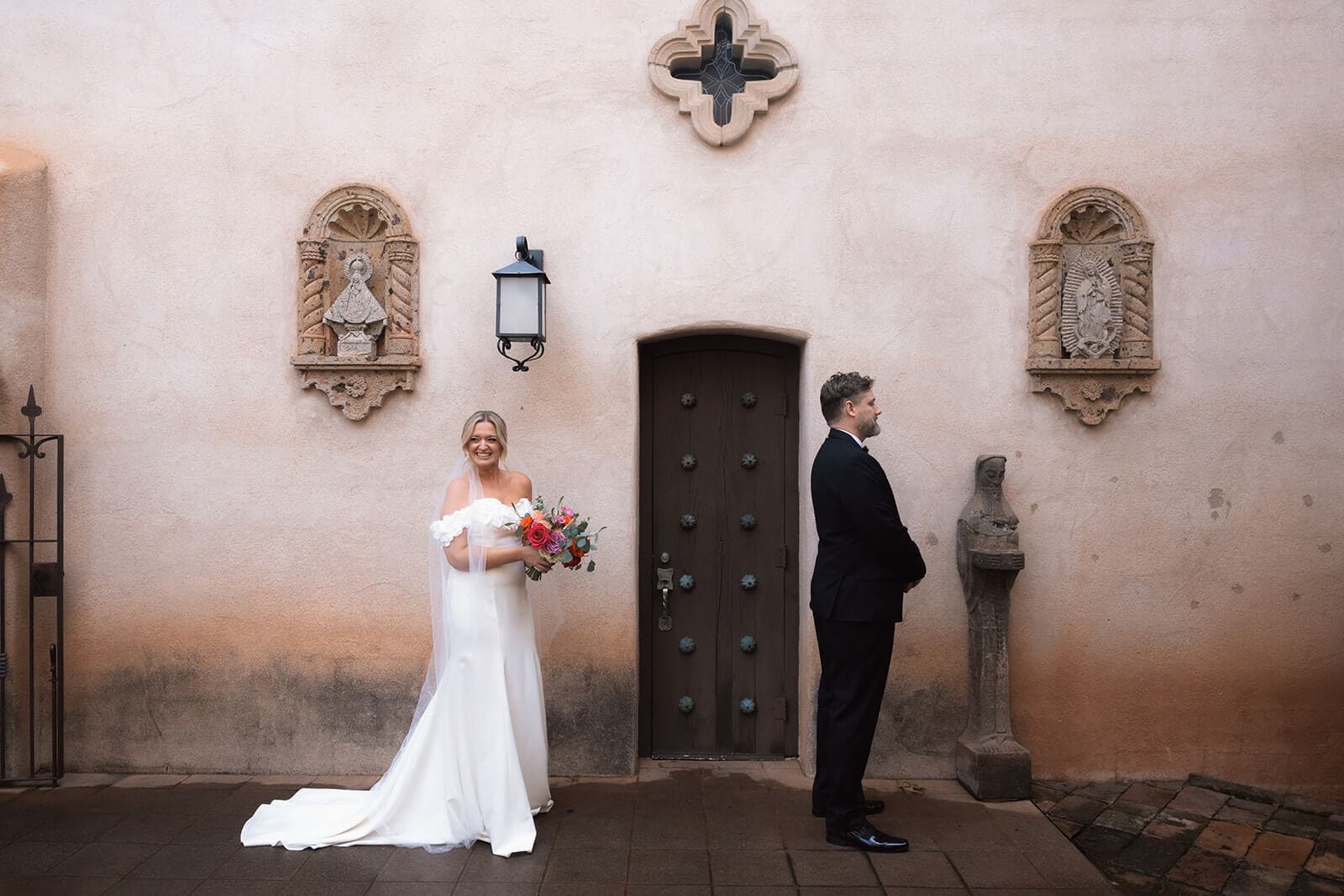Bride surprising groom during a romantic first look outside a historic chapel before their intimate elopement ceremony