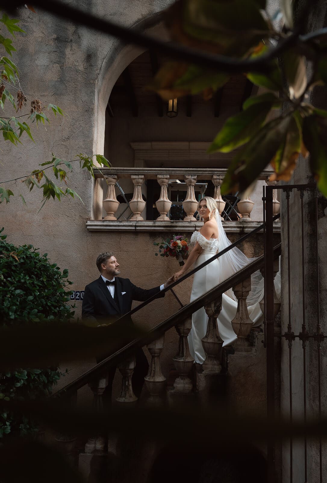 Bride and groom standing on a staircase during a luxury wedding venue first look