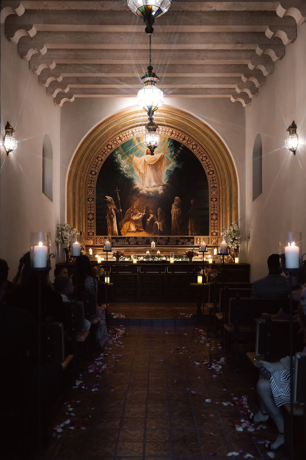 Interior view of a chapel altar with wooden beams and religious artwork during a wedding ceremony at Tlaquepaque.