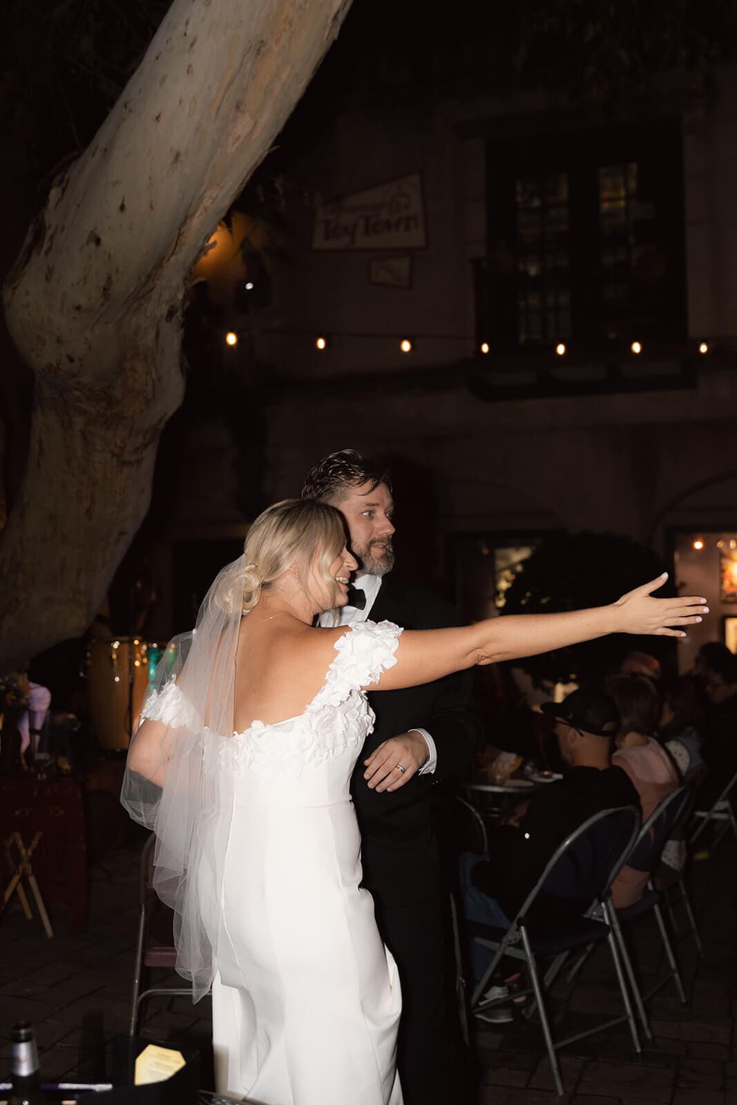 Bride dancing with guests during a wedding reception at Tlaquepaque with string lights glowing in the background.