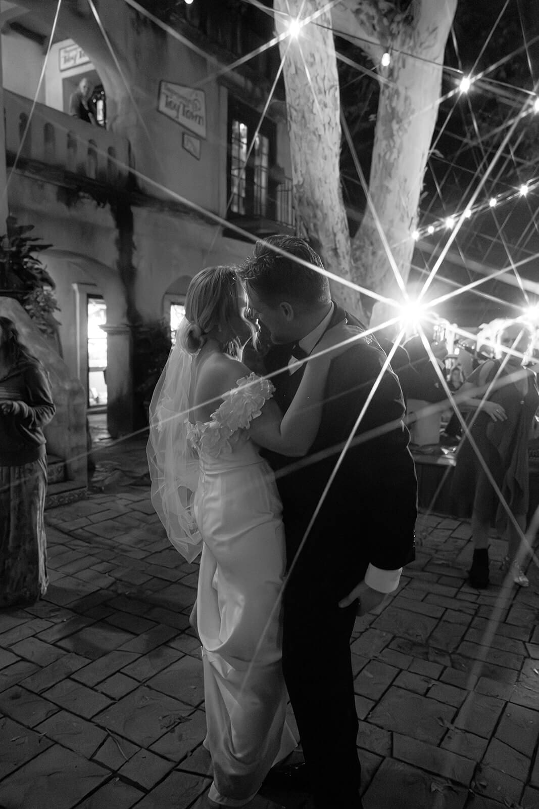 Black and white photo of the bride and groom dancing together outdoors at night during their reception at Tlaquepaque.