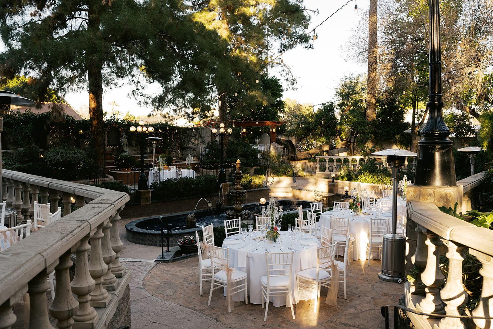 Outdoor reception tables set with white linens and chiavari chairs on the garden patio at The Wright House wedding venue in Mesa Arizona
