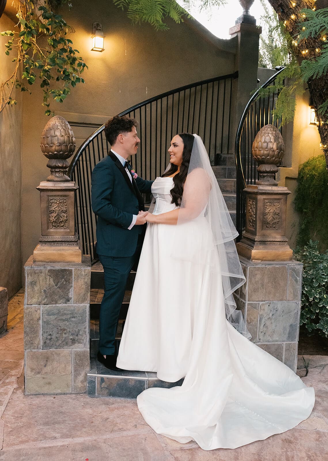 Bride and groom sharing a quiet moment together framed by stone archway gates at The Wright House, a garden wedding venue in Mesa Arizona
