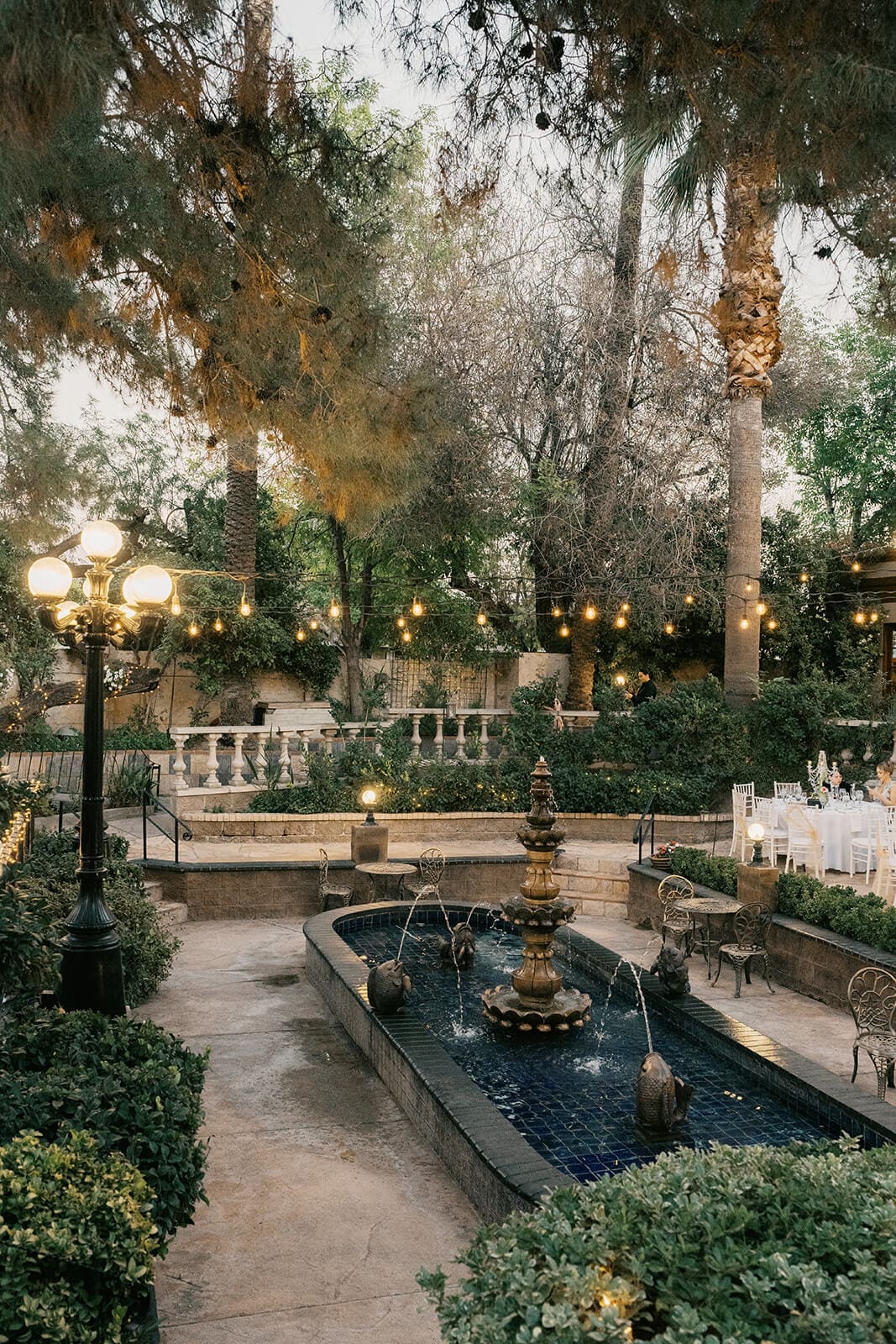 Lush garden courtyard with a stone fountain and string lights at The Wright House wedding venue in Mesa Arizona

