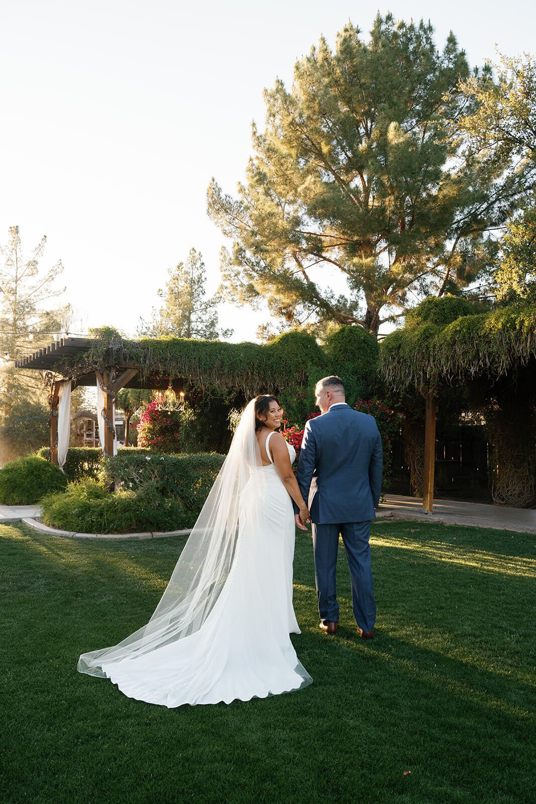 Bride and groom sharing a quiet moment on the lawn surrounded by mature trees at Shenandoah Mill, a historic garden wedding venue in Gilbert Arizona
