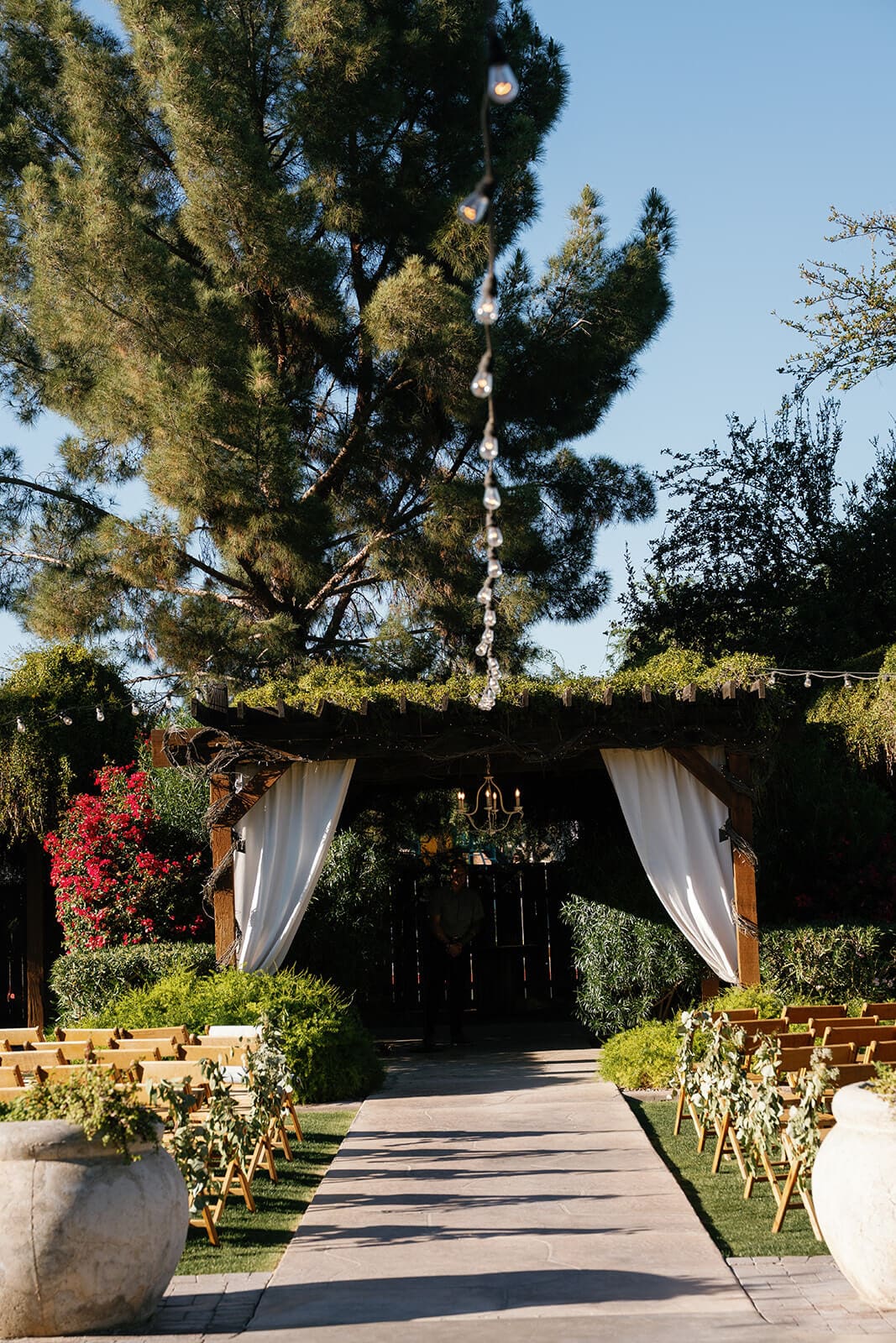 Empty ceremony aisle lined with draped fabric and florals leading to the altar at Stonebridge Manor garden wedding venue in Mesa Arizona
