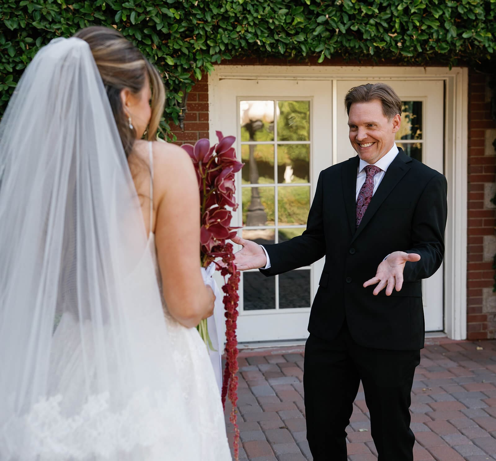 Father reacting with excitement during a first look outside the ivy-covered manor house at Stonebridge Manor.