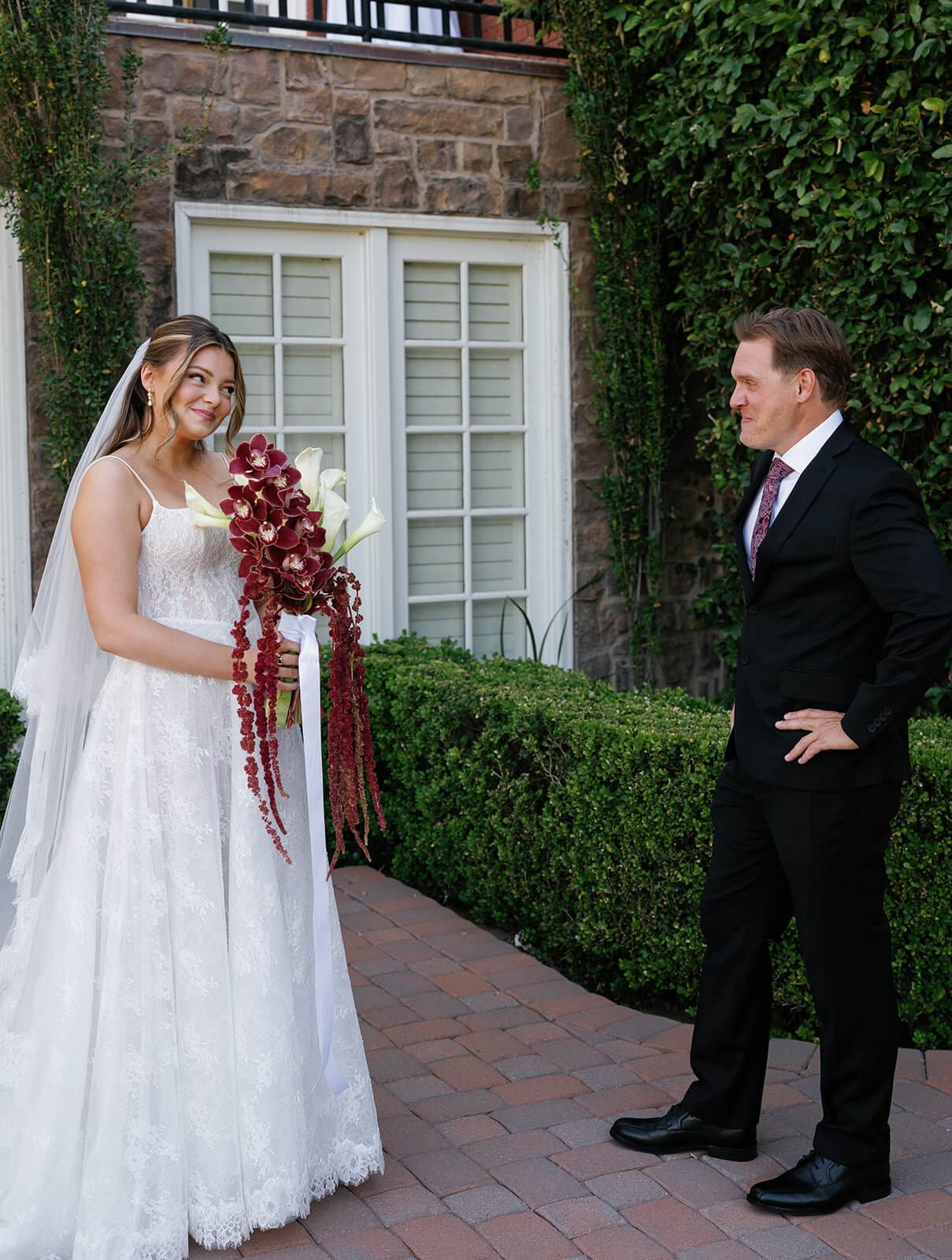 Bride and father seeing each other for the first time during their wedding day first look in front of the manor house at Stonebridge Manor.