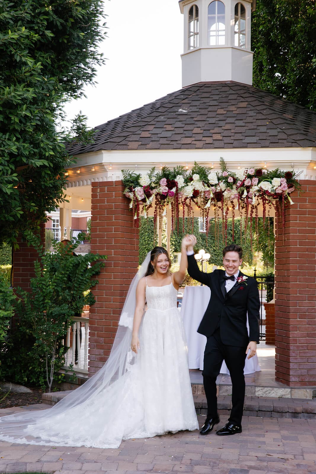 Bride and groom celebrating their marriage while walking out of the gazebo ceremony site at Stonebridge Manor.