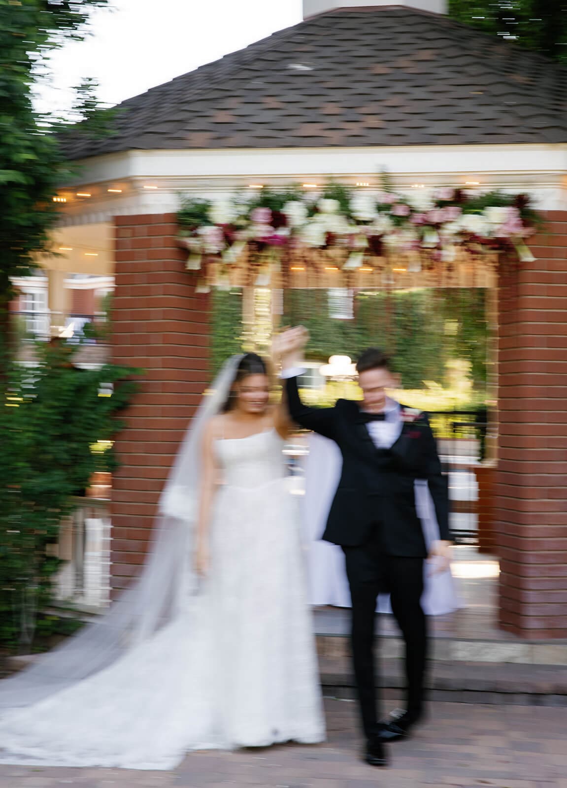Bride and groom walking back down the aisle after their outdoor wedding ceremony at Stonebridge Manor, smiling as guests celebrate around them.