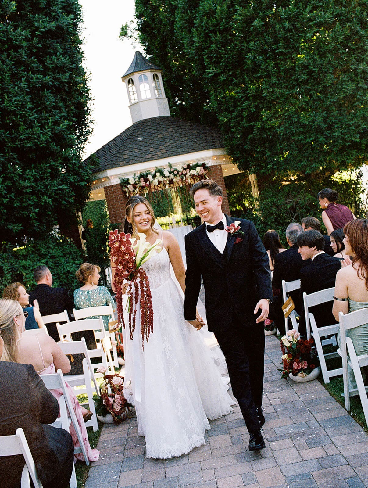 Bride and groom walking back down the aisle laughing after their ceremony at Stonebridge Manor garden wedding venue in Mesa Arizona
