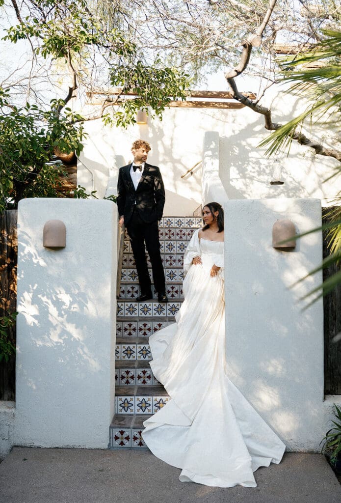Bride and groom posing on tiled outdoor stairs at Joshua Tree House during their intimate Airbnb wedding in Tucson.