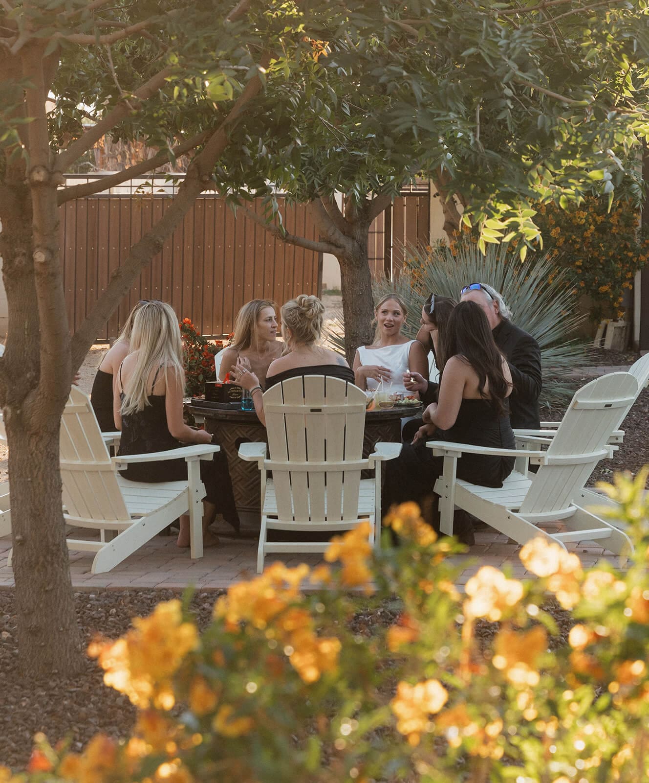 Wedding guests gathered around an outdoor dinner table during a cozy Airbnb wedding weekend.