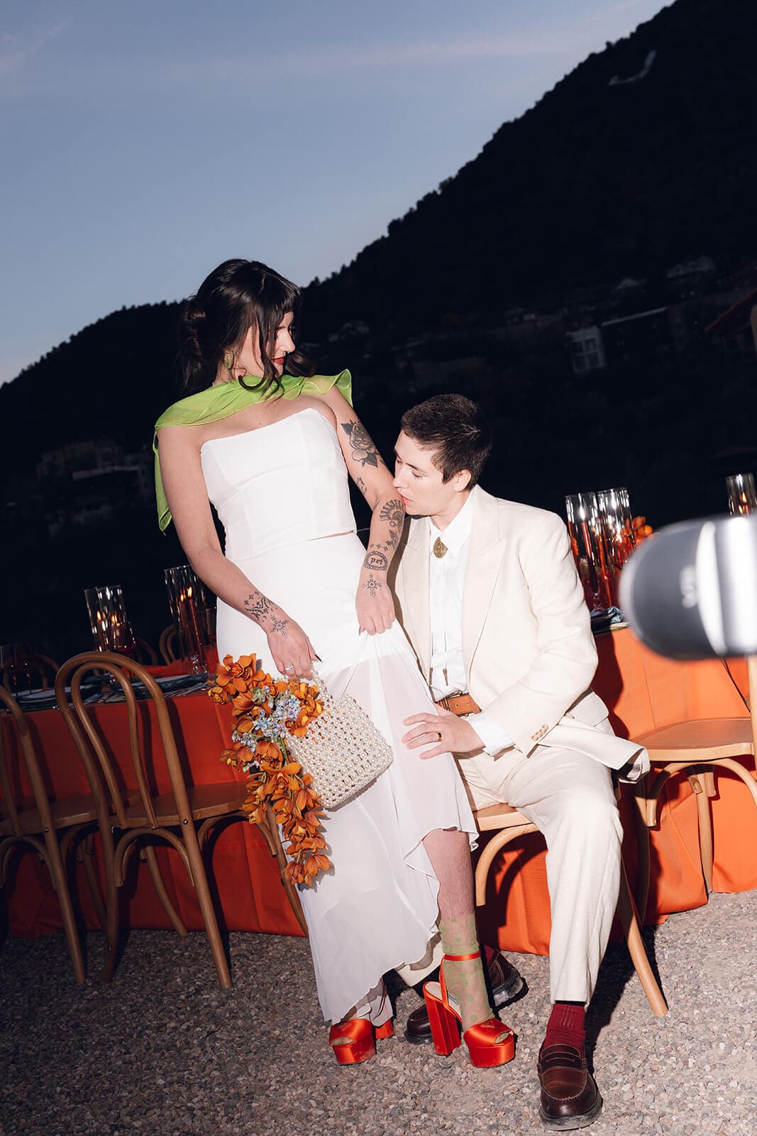 Couple seated close together at dusk, mountain silhouette fading into the darkening sky behind them at The Little Daisy wedding venue