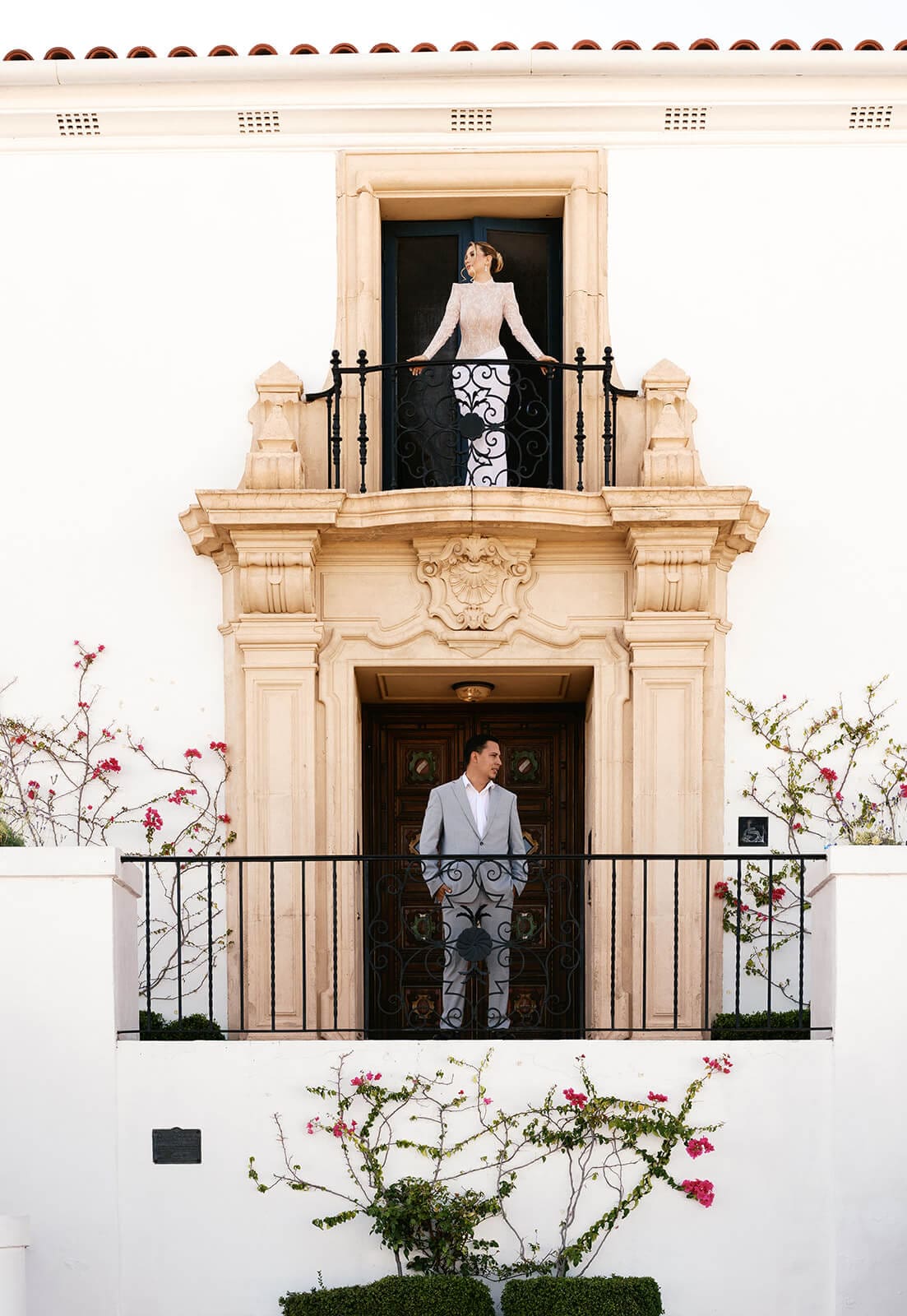 Newlyweds standing on separate balconies of an ornate historic mansion in Arizona.